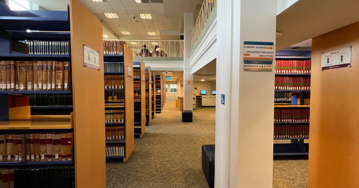 図書館の書架と通路が並ぶ明るい館内