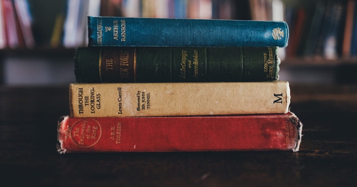 図書館のテーブルに積まれたクラシックな本の山