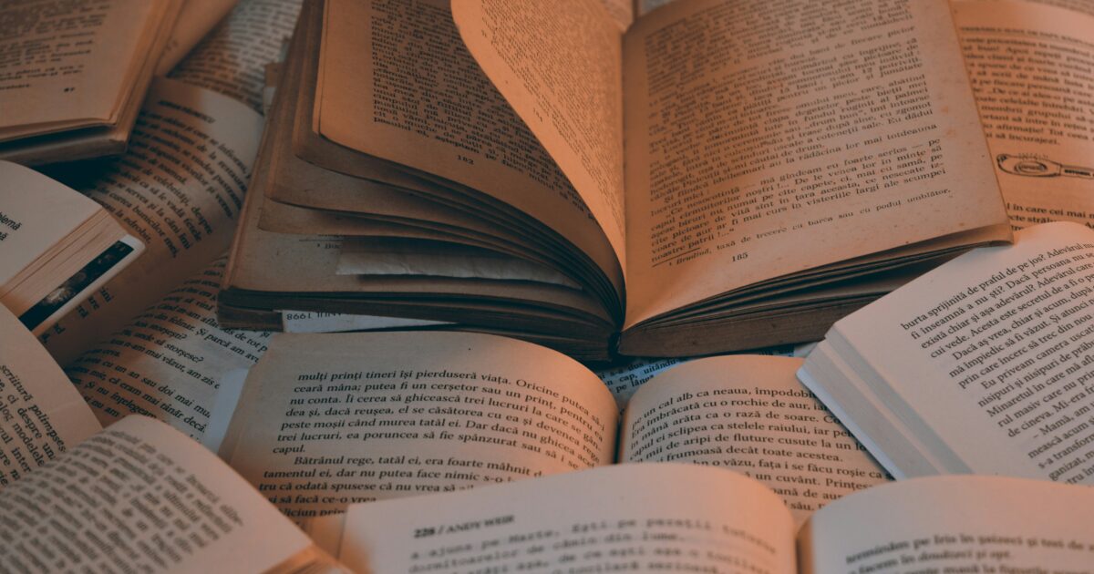 複数の古本が開かれた状態で重なった読書の風景