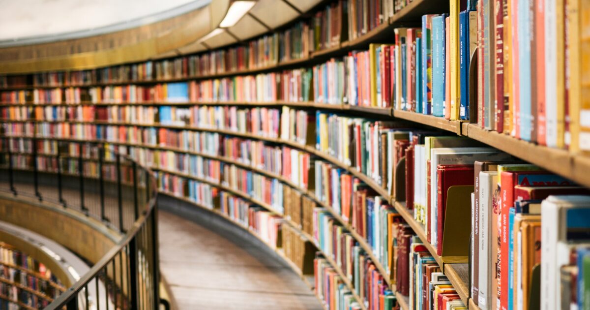 曲線状の本棚が並ぶモダンな図書館の内部